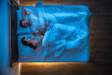 Yatakta uyuyan çift. Yukarıdan manzara, akşam vakti