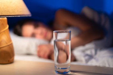 Uyuyan kadının arka planında votka içmek.