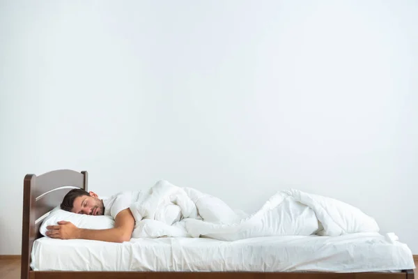 Uomo Che Dorme Sul Letto Sullo Sfondo Bianco — Foto Stock