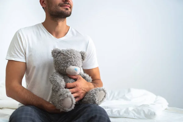 Pria Yang Bahagia Duduk Dengan Mainan Lembut Tempat Tidur Latar — Stok Foto