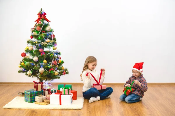 Junge Und Mädchen Packen Der Nähe Des Weihnachtsbaums Geschenkboxen Aus — Stockfoto
