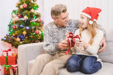 Mutlu yaşlı adam bir dedeye hediye kutusu veriyor.