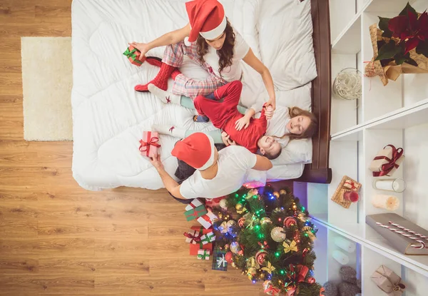Das Fröhliche Familienvergnügen Bett Neben Dem Weihnachtsbaum Blick Von Oben — Stockfoto