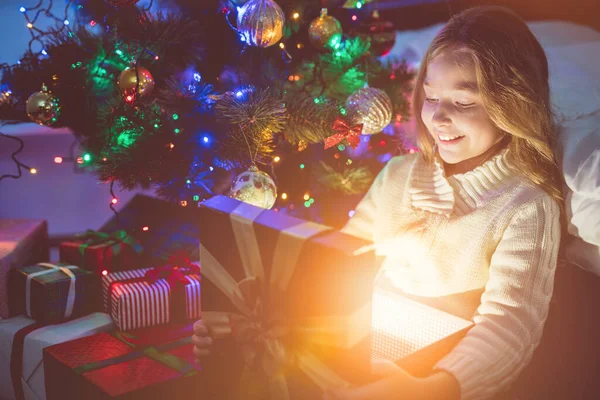 Das Lächelnde Mädchen Öffnet Den Leuchtkasten Neben Dem Weihnachtsbaum Abend — Stockfoto