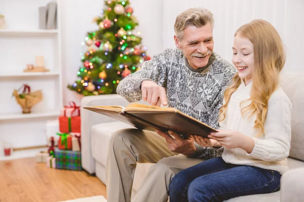 Menina Com Avô Olha Para Álbum Fotos Perto Árvore Natal — Fotografia de Stock