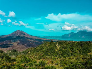 Batur Dağı - Endonezya, Bali 'nin tropikal ormanları Kintamani volkanı arkasında ve bulutlar üzerinde uçuyor
