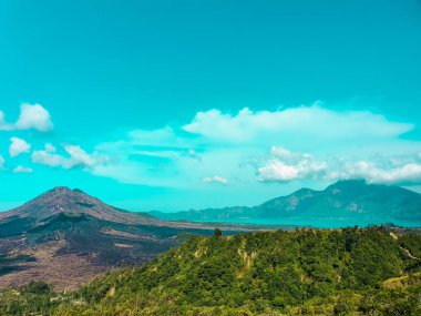 Batur Dağı - Endonezya, Bali 'nin tropikal ormanları Kintamani volkanı arkasında ve bulutlar üzerinde uçuyor