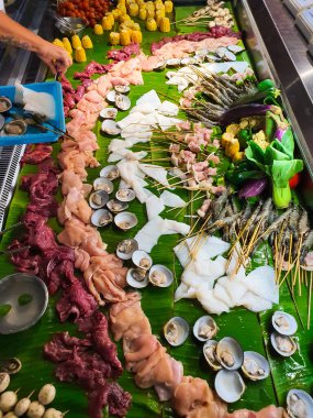 Bali çiğ deniz ürünleri - taze kesilmiş mürekkep balığı, karides ve barbekü için tavuk ve biftek. Bali yemeği