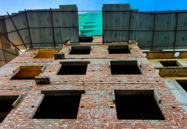 İnşaat halindeki bina. Gündüz vakti inşaat halindeki çok katlı bir apartman. Binanın yarısı inşa edilmiş