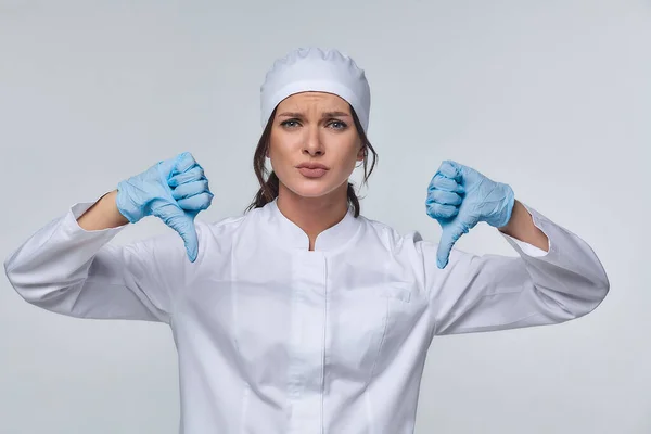 Medical concept of a female doctor in a white coat with a stethoscope, doctor. A female hospital worker looks at the camera and smiles, Studio, White background