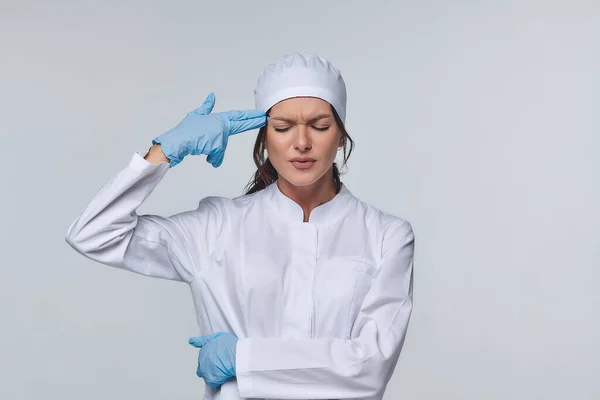 Medical concept of a female doctor in a white coat with a stethoscope, doctor. A female hospital worker looks at the camera and smiles, Studio, White background