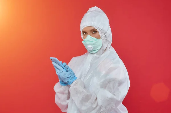 Kimyasal giysili kadın doktor. Telefonu tut.
