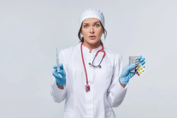 Medical concept of a female doctor in a white coat with a stethoscope, doctor. A female hospital worker looks at the camera and smiles, Studio, White background