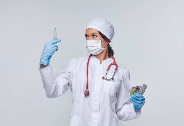 Steteskoplu beyaz önlüklü bir kadın doktor tıbbi konsepti doktor. Kadın bir hastane çalışanı kameraya bakar ve gülümser, stüdyo, beyaz arka plan.