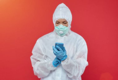 Kimyasal giysili kadın doktor. Telefonu tut.