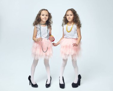 İki küçük kız annelerinin yüksek topuklu ayakkabılarıyla oynuyorlar. Poz verirler ve yetişkin olmaya çalışırlar. Stüdyo, White geri döner.