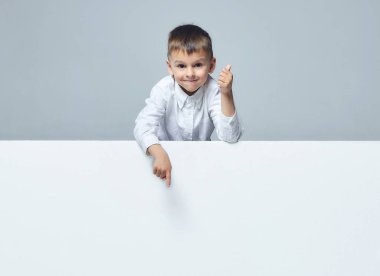 Küçük çocuk boş bir yeri işaret ediyor. Başparmak yukarı. beyaz sırt