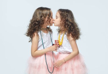 İki küçük kız annelerinin yüksek topuklu ayakkabılarıyla oynuyorlar. Poz verirler ve yetişkin olmaya çalışırlar. Stüdyo, White geri döner.