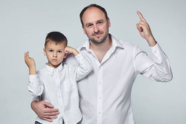 Baba ve oğul stüdyoda mutlu poz veriyorlar. Babalık, ilişki psikolojisi. Stüdyo, White geri döndü.