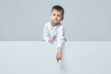 Küçük çocuk boş bir yeri işaret ediyor. Başparmak yukarı. beyaz sırt