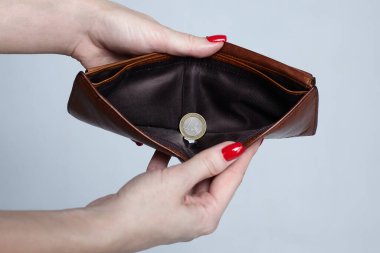 Kızın elinde kahverengi bir çanta ve bir Euro bozukluk var. Yoksulluk kavramı..