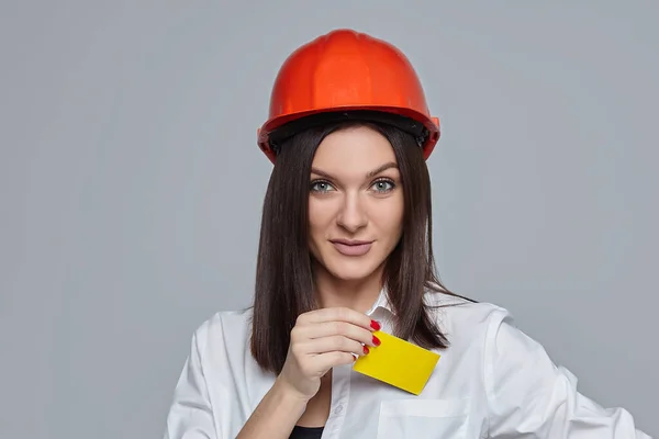 Uma Menina Com Capacete Laranja Com Cartão Visita Mão Sobre — Fotografia de Stock