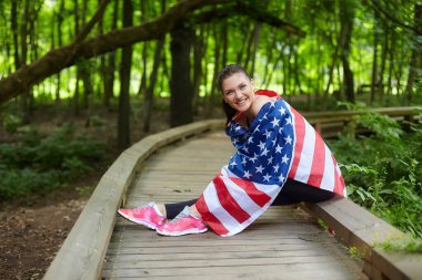 Forest Park 'ta Amerikan bayrağıyla poz veren çekici kız.
