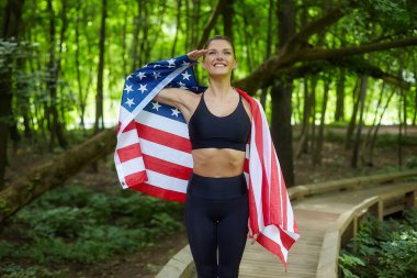 Forest Park 'ta Amerikan bayrağıyla poz veren çekici kız.