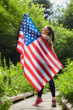 Forest Park 'ta Amerikan bayrağıyla poz veren çekici kız.