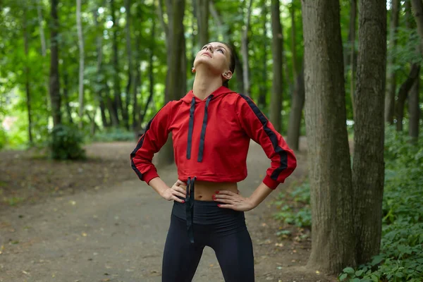 スポーツウェアの魅力的な女の子は森林公園のコースで体操をしています — ストック写真