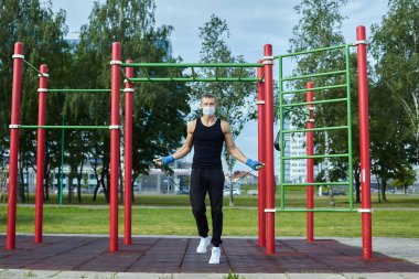 Sabah antrenmanda koruyucu maskeli bir sporcu.