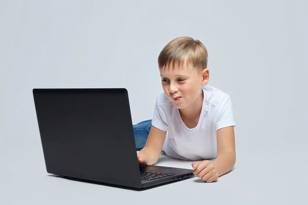Söt Blond Pojke Med Ett Leende Tittar Laptopen Fotografering Studion — Stockfoto