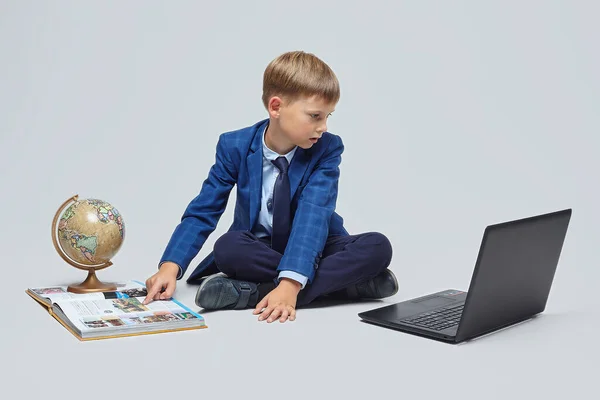 Okul Takımlı Sarışın Çocuk Dizüstü Bilgisayarın Kürenin Kitabın Önünde Oturuyor — Stok fotoğraf