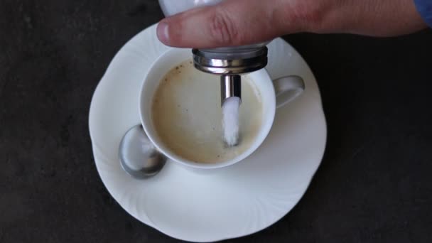 Homme main verse le sucre dans le café et le remuer 