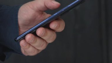 Adam kurdeleyi sosyal ağda bir cep telefonuna kaydırıyor ve bir mesaj yazıyor.