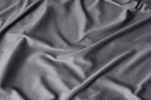 Katlanmış siyah kumaş masanın üzerinde yatıyor.