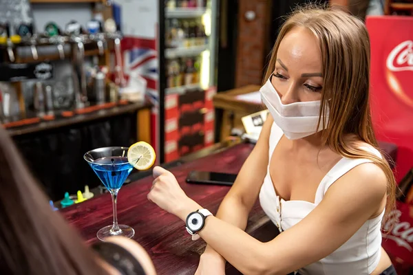girl in a medical mask in a pub. girl in a restaurant. girl at the bar