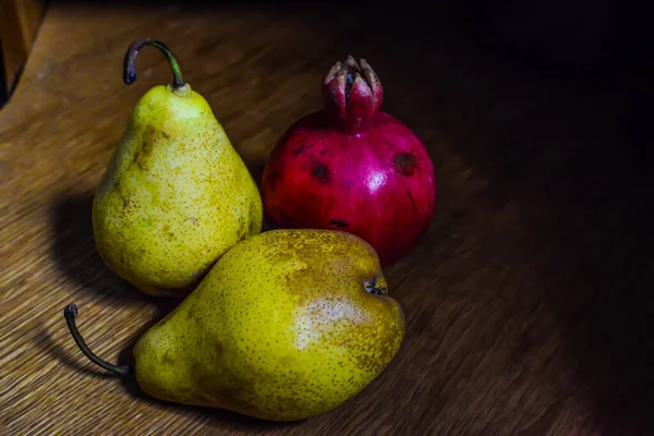 新鮮な有機黄色の梨と1つのザクロの木のテーブルのカップル。選択的焦点. — ストック写真