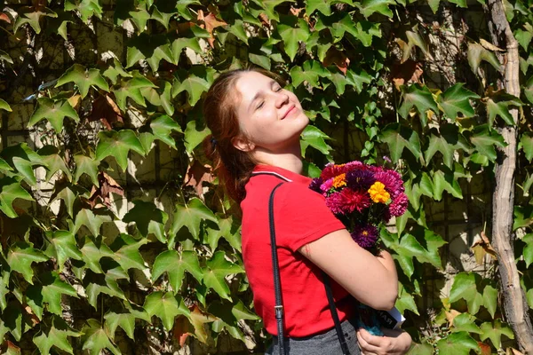 Vacker Ung Kvinna Med Bukett Blommor Nära Grön Vägg Buskar — Stockfoto