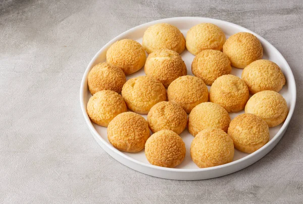 Chou pastry cookies in a white plate isolated on gray background. — Stock Photo, Image