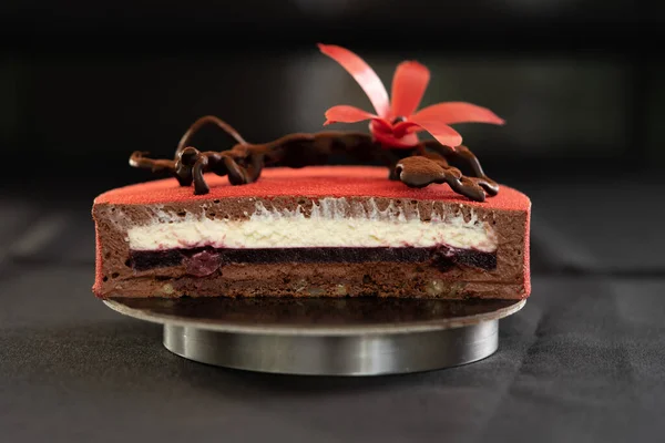 Połowa lub plasterek czerwonego tortu urodzinowego z czekoladowym kwiatem. Izolacja — Zdjęcie stockowe