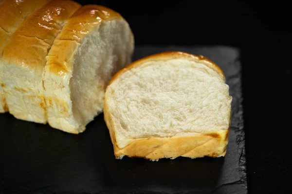 Ekmek kes, siyah arka planda somun ekmek. Uzayı kopyala Fırın kavramı