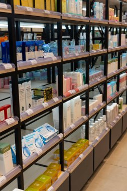 Taşkent, Özbekistan, 18 Ağustos 2025: Bir kozmetik mağazasında, çeşitli markalar, ambalaj tasarımları ve arka planda müşteriler ile perakende satış raflarında düzgün düzenlenmiş cilt bakımı ve güzellik ürünleri