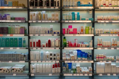 Taşkent, Özbekistan, 18 Ağustos 2025: Bir kozmetik mağazasında, çeşitli markalar, ambalaj tasarımları ve arka planda müşteriler ile perakende satış raflarında düzgün düzenlenmiş cilt bakımı ve güzellik ürünleri