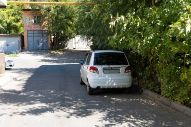 Şymkent, Kazakistan, 30 Ağustos 2025: Kavşakta giden arabalar, trafik ışıkları, apartmanlar ve açık mavi gökyüzü.