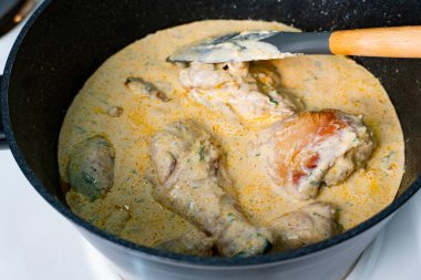 Sobanın üstünde siyah bir tencerede kaynamış, kaymak gibi bir bitki sosunda kaynayan sulu tavuk parçaları tarif blogları, yemek pişirme dersleri ve yemek reklamları için mükemmel.