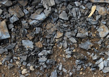 Arka plan olarak kamp ateşinden sonra yerdeki kömürü kurutun.