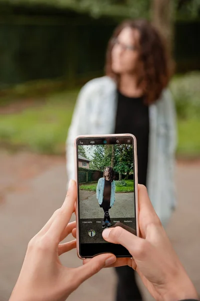 Νεαρή Γυναίκα Φωτογραφίζει Τον Φίλο Της Κινητό Στο Πάρκο — Φωτογραφία Αρχείου