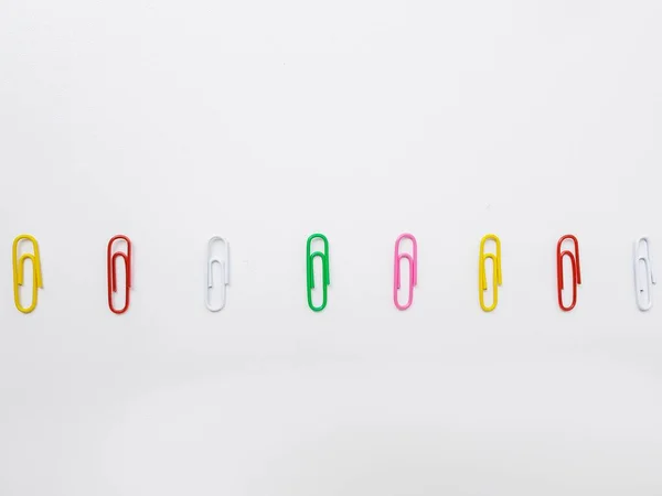Clipes de papel metálicos multicoloridos em um fundo branco . — Fotografia de Stock