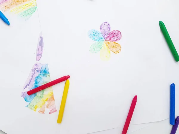 Lápis de cera coloridos. Uma impressão de mão em uma folha de papel branca . — Fotografia de Stock